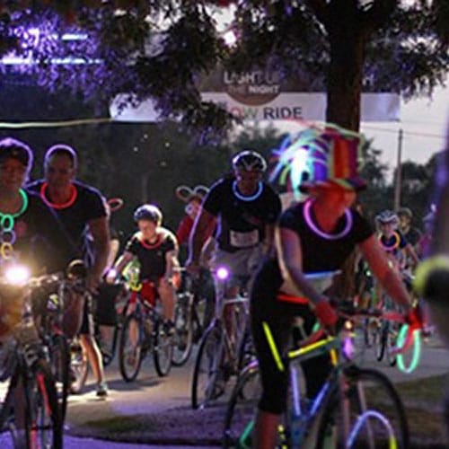 Bike riders on bikes at night with glow lights