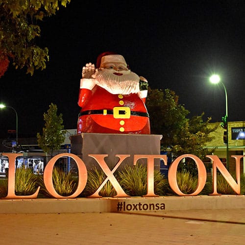 Loxton town entry sign with large red santa claus statue on top